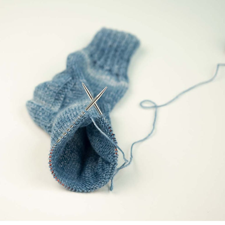 addiSockwonder Lace circular knitting needle 25cm - 710-7 - Blue knitted sock with a needle on a white background