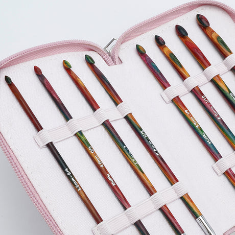 KnitPro Symfonie 2 Afghan Tunisian crochet hook set - A set of colorful crochet hooks stored in a light pink zippered case with white elastic loops. The hooks have a marbled, multicolor pattern with shades of red, green, orange, and black, and some white text is visible on the handles.
